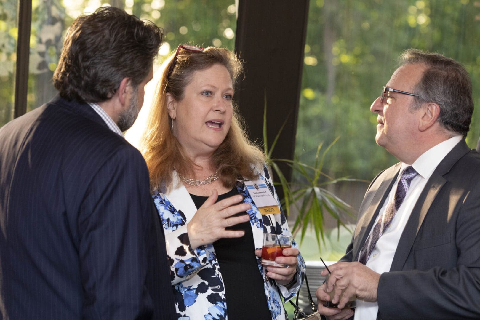 Three business people talking at an event.