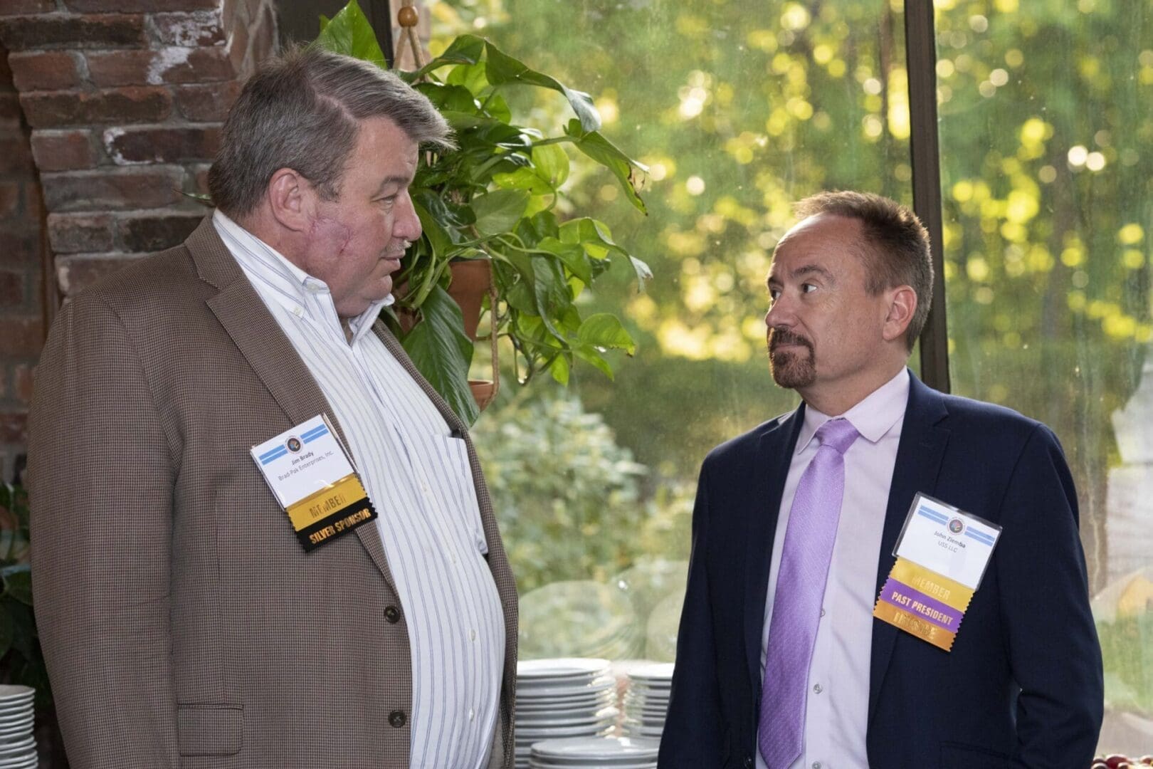 Two men talking to each other at an event.