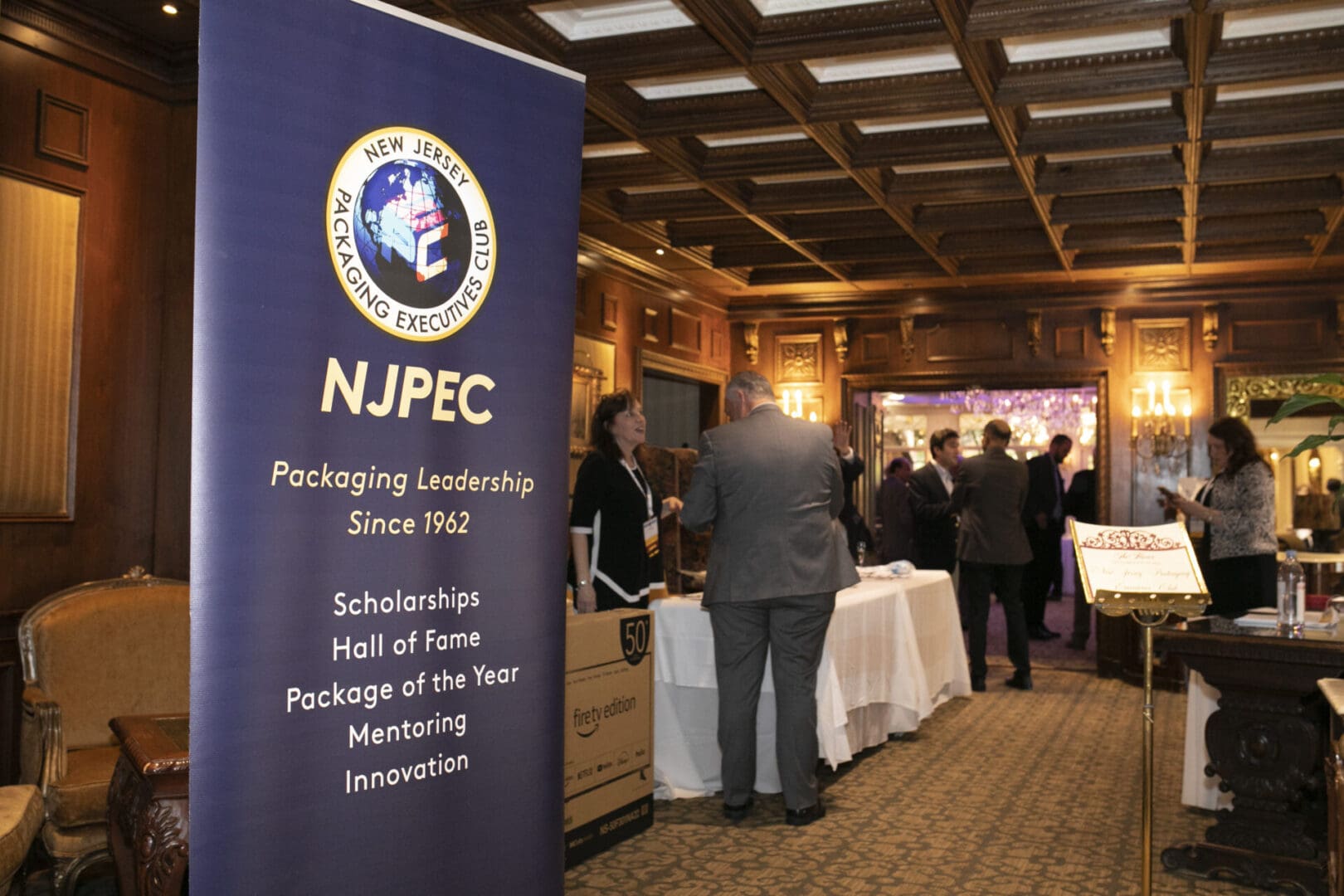 A group of people standing in a room with a banner that says nfpc.