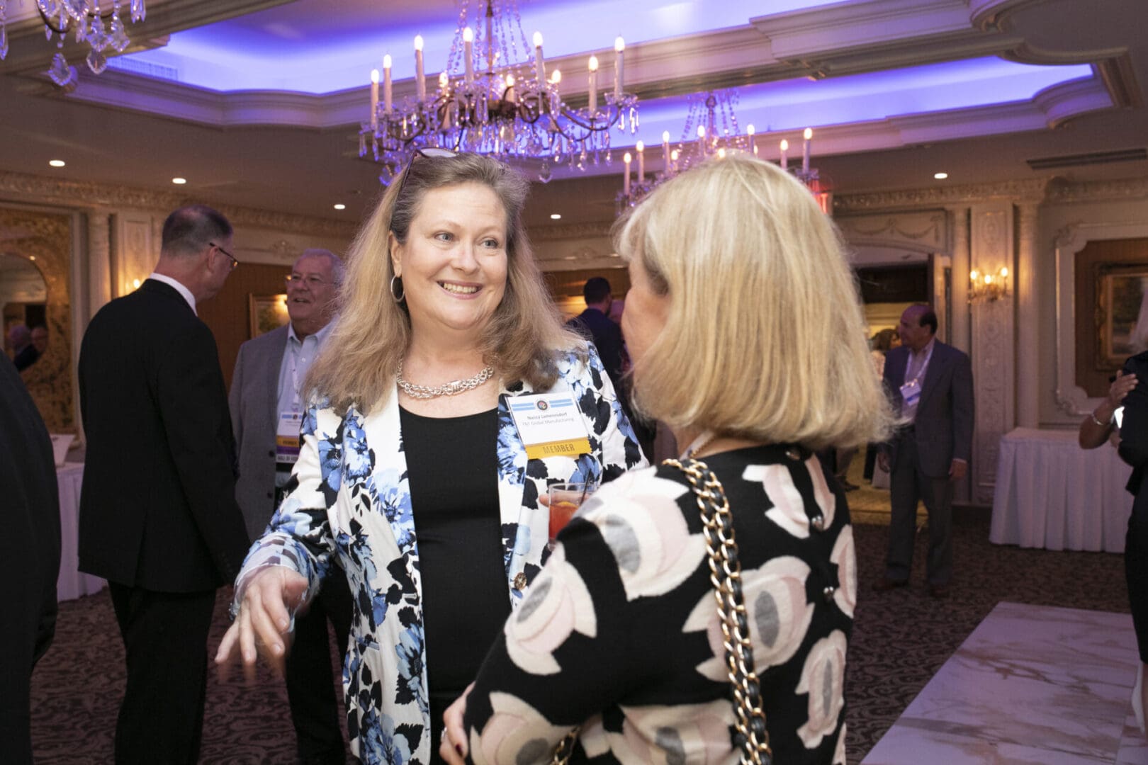 Two women talking to each other at a business event.
