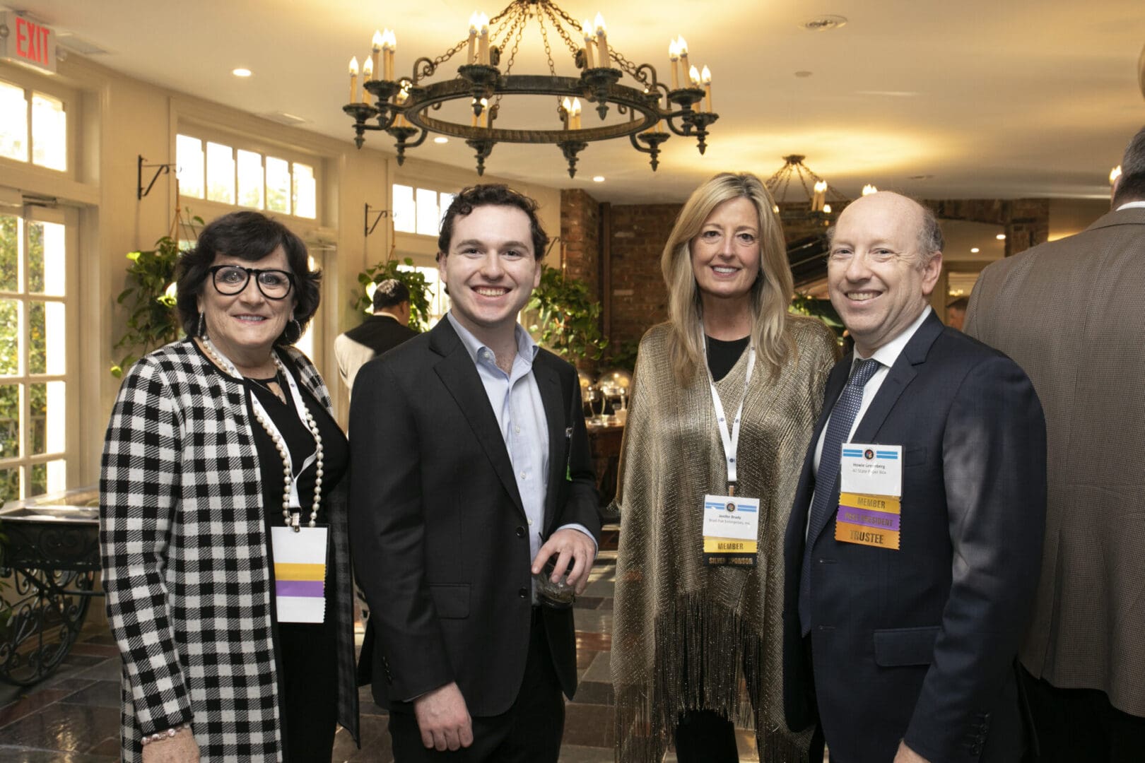Four people standing together at a business event.