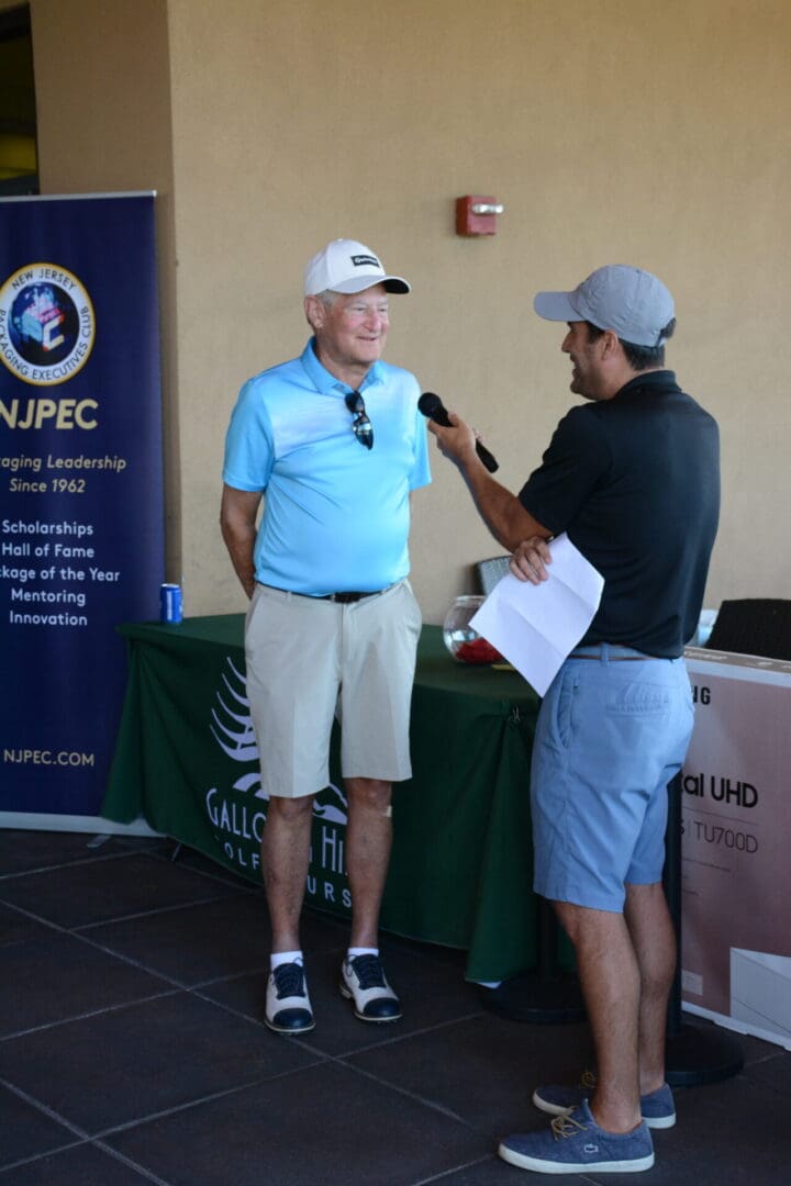 A man talking to a reporter at a golf tournament.