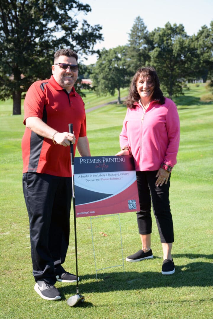 A man and woman posing for a photo on a golf course.