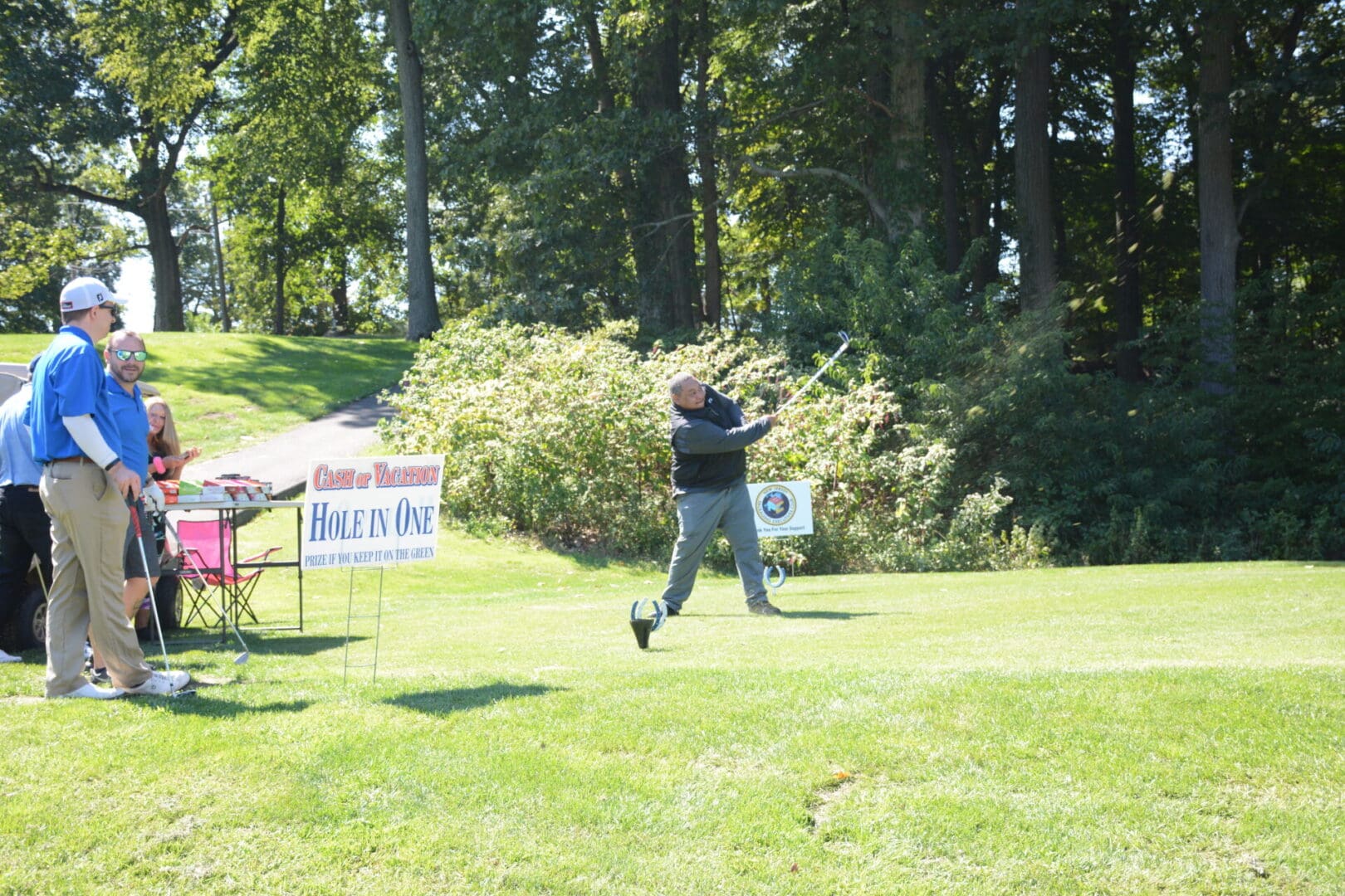 A man swinging a golf club at a golf tournament.
