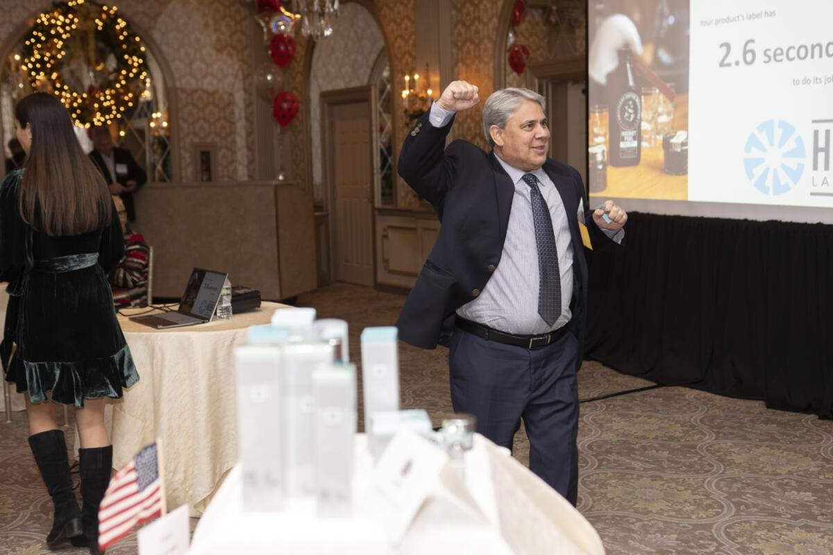 man with gray hair raising fist in front of projected presentation