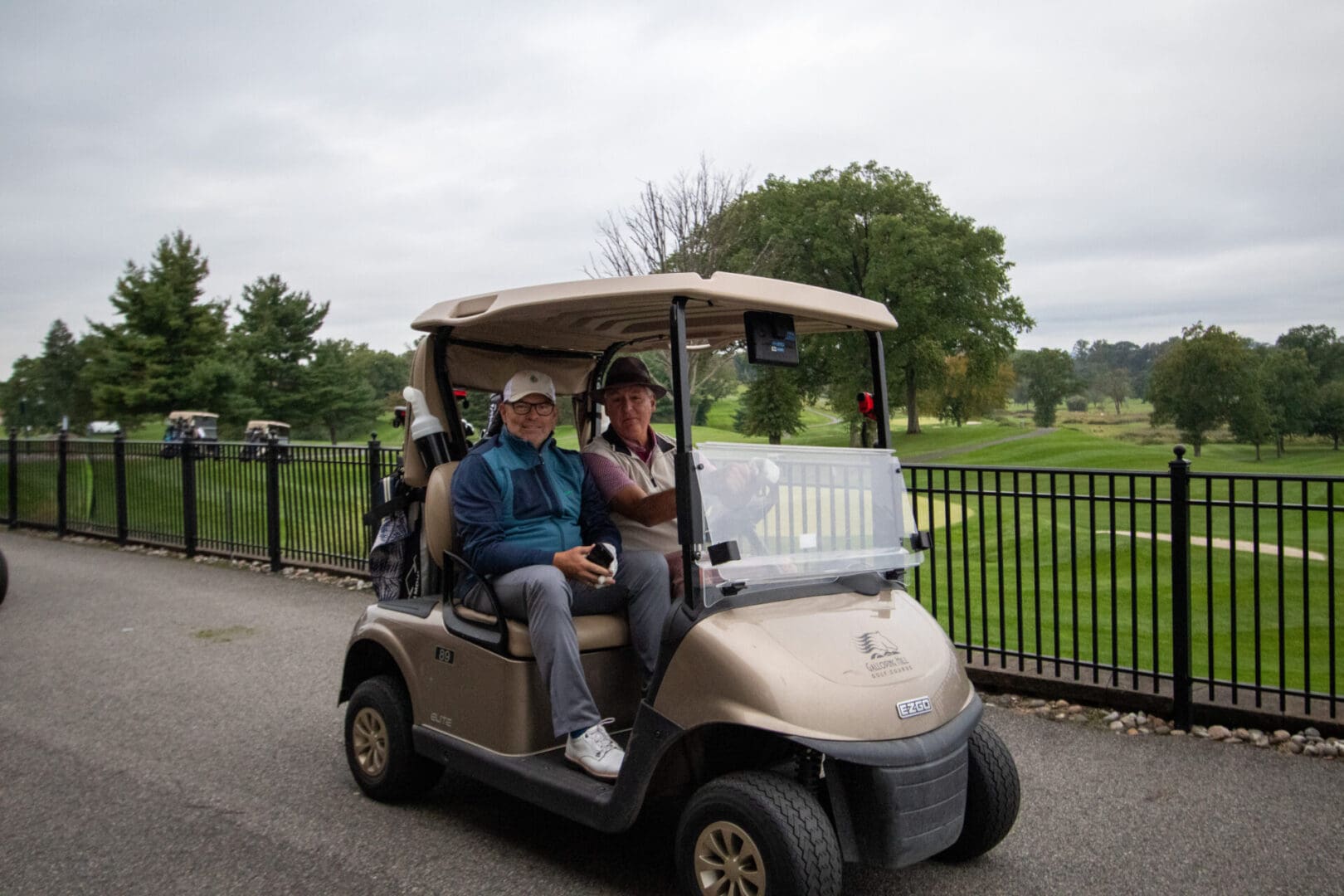 two middle-aged men on a golf cart