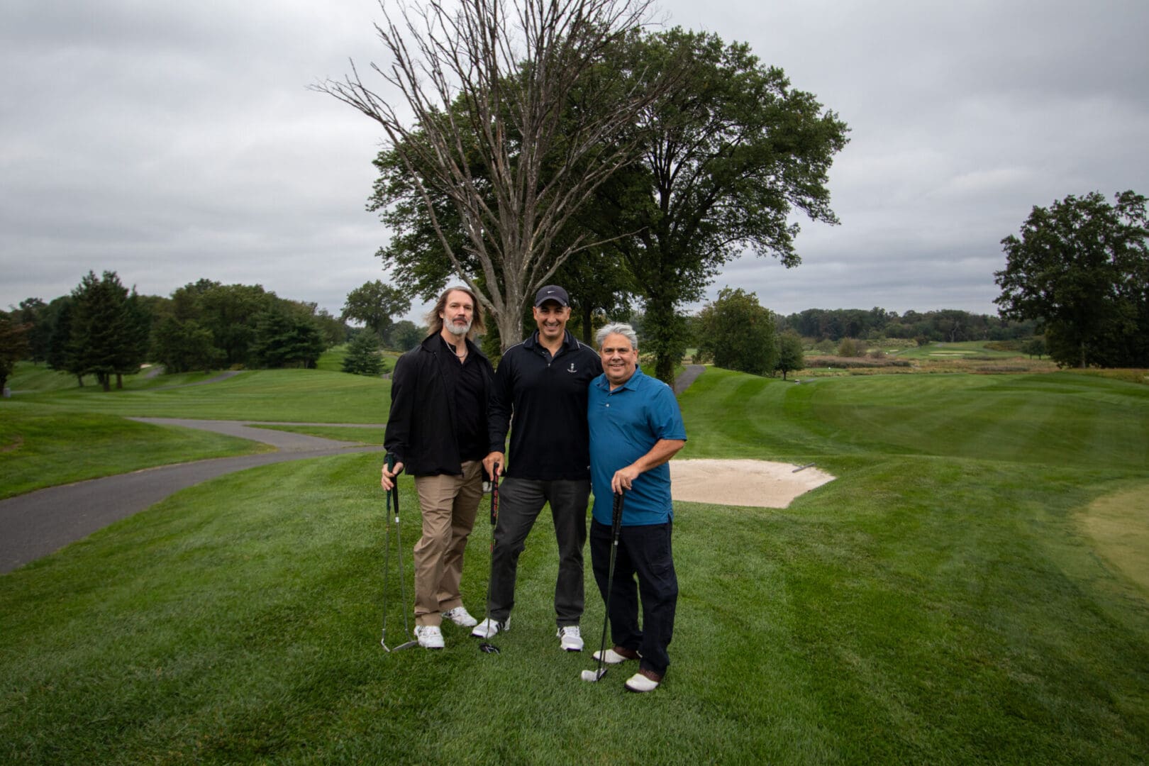 3 men in front of a tree