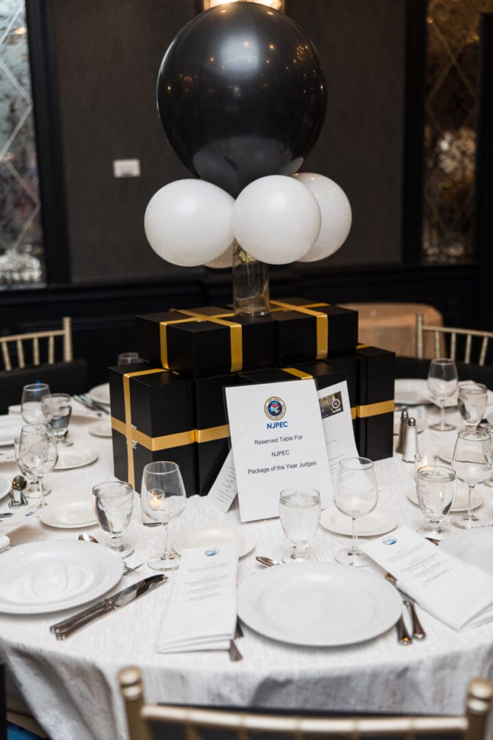 A black and white table setting with balloons.