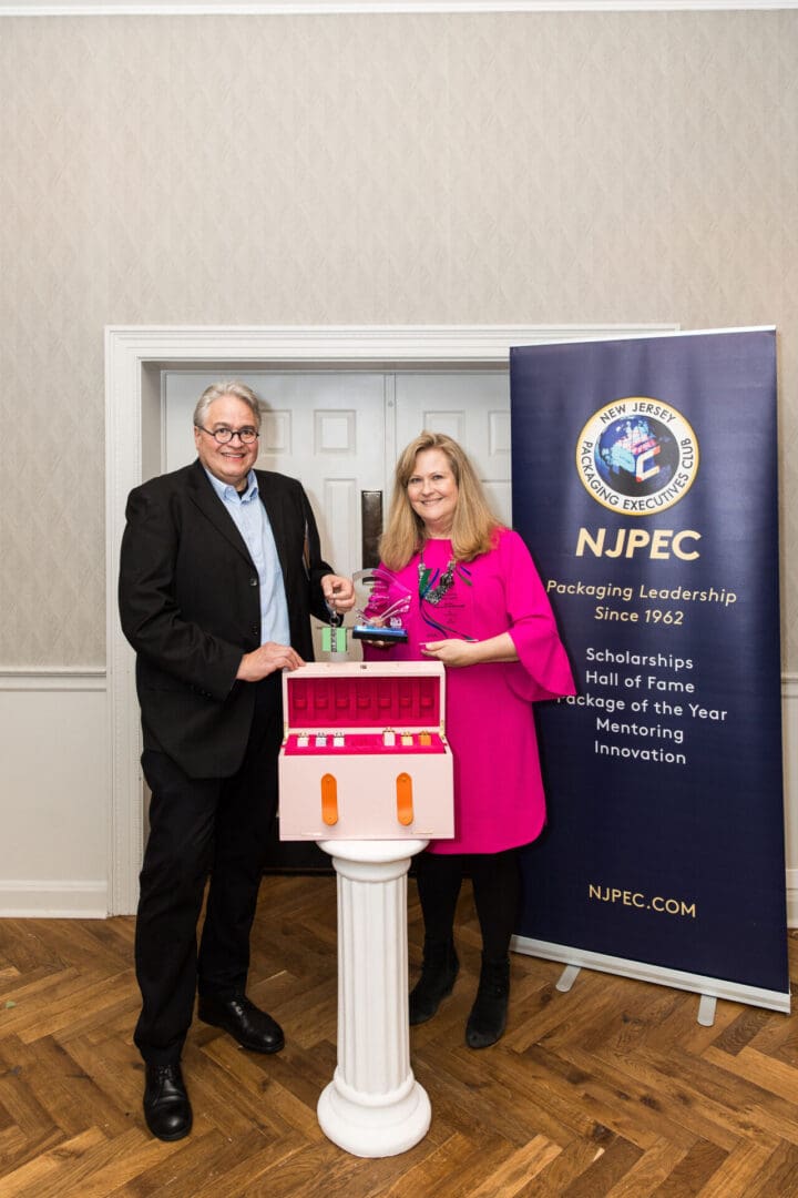 A man and woman standing next to a box with a npfc logo on it.