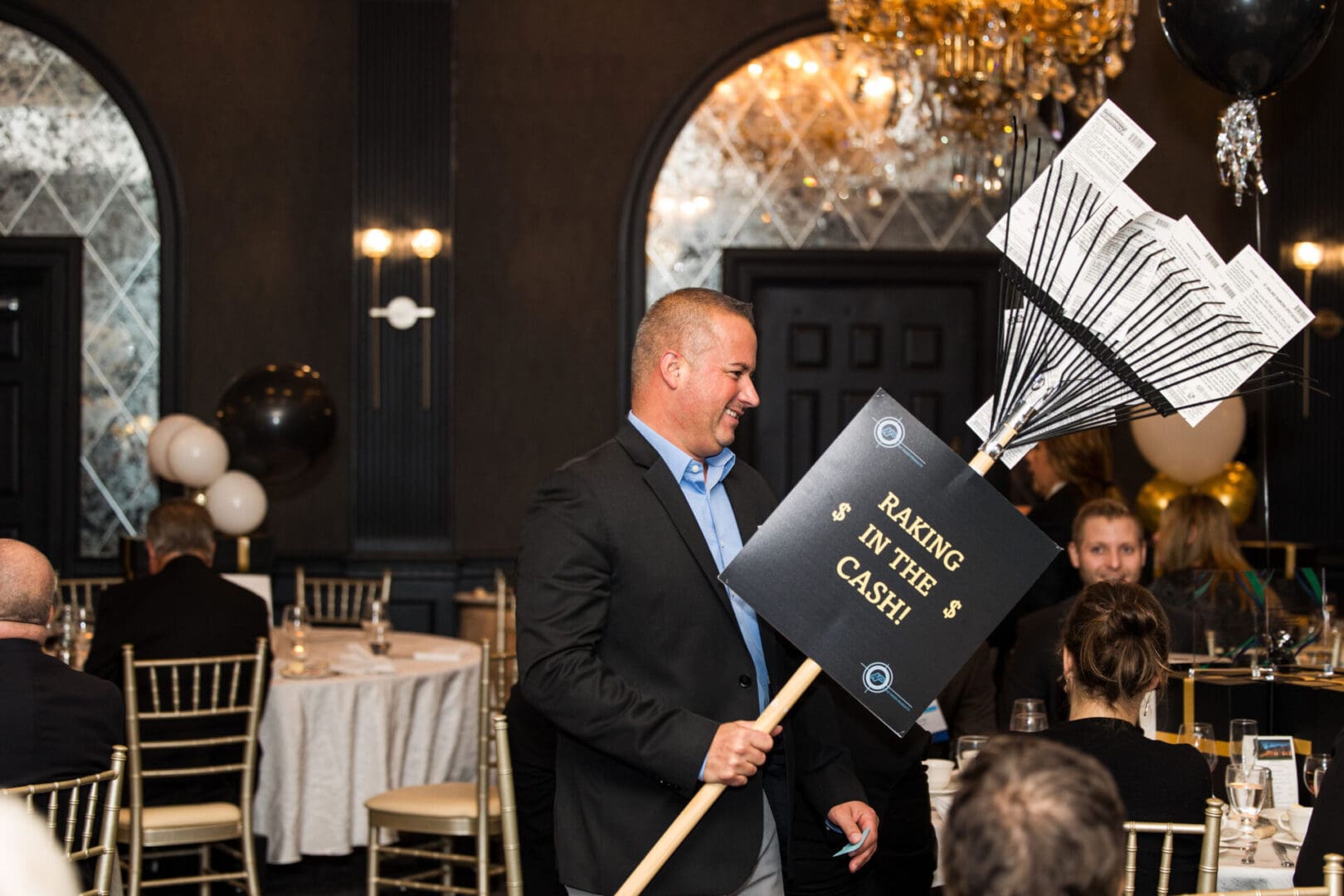 A man holding a sign at a banquet table.