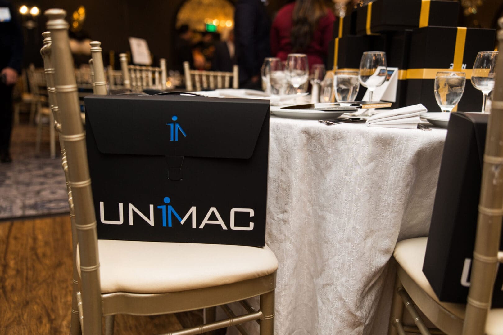 A table with a black and gold unmag logo on it.
