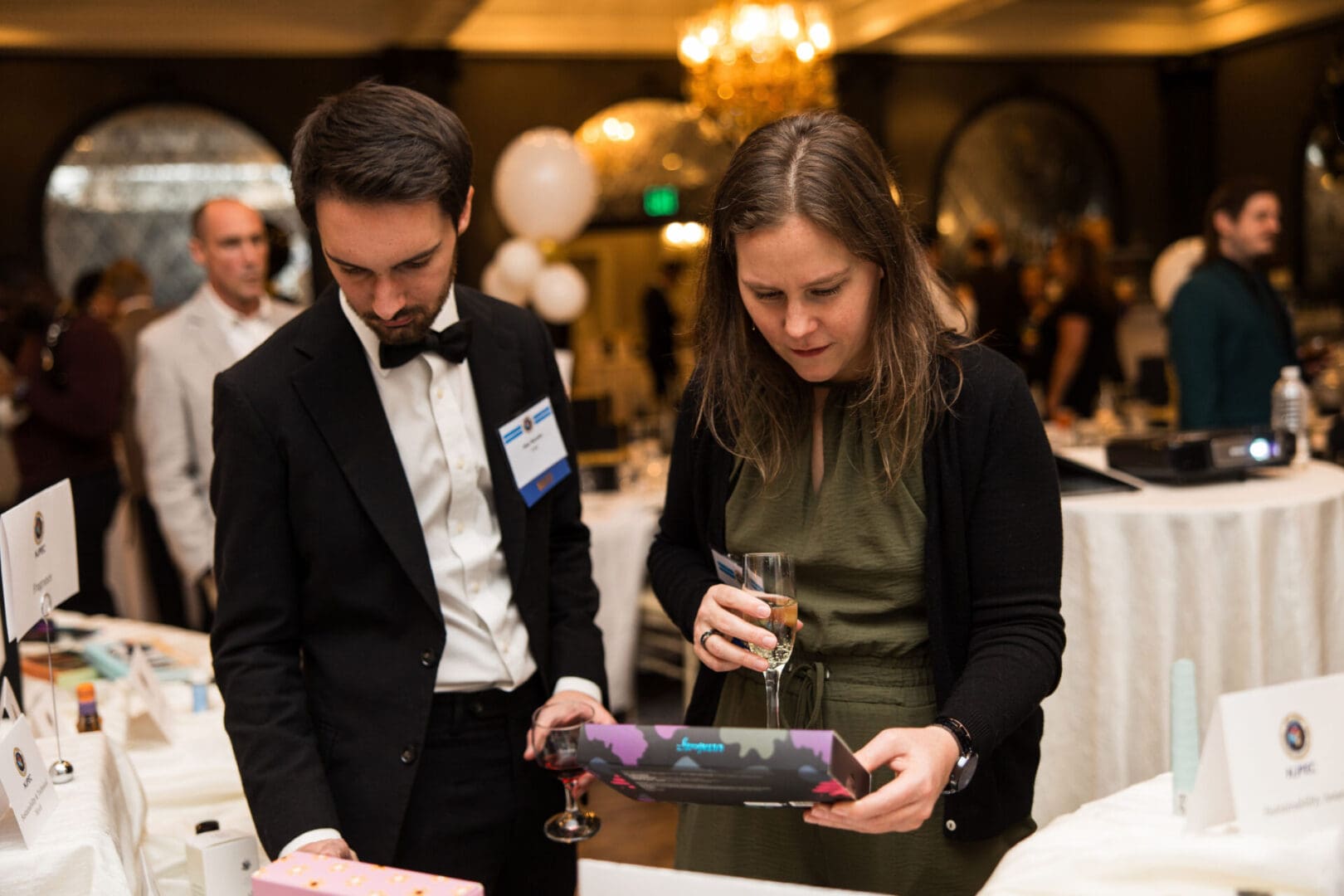 A man and woman looking at a gift at a party.