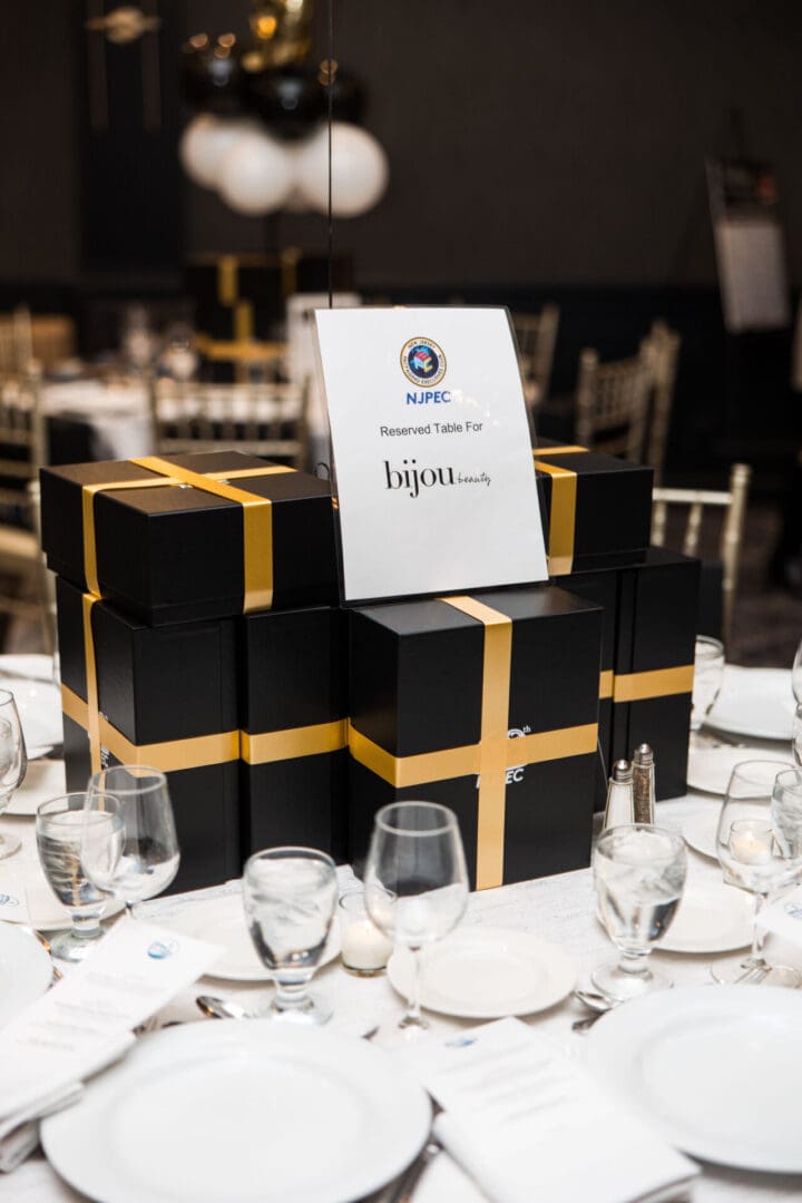A black and gold table setting with a gift box.