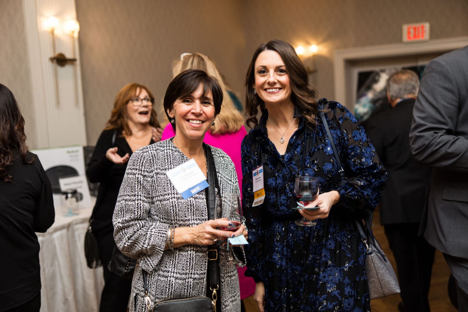 Two women smiling at a business event.