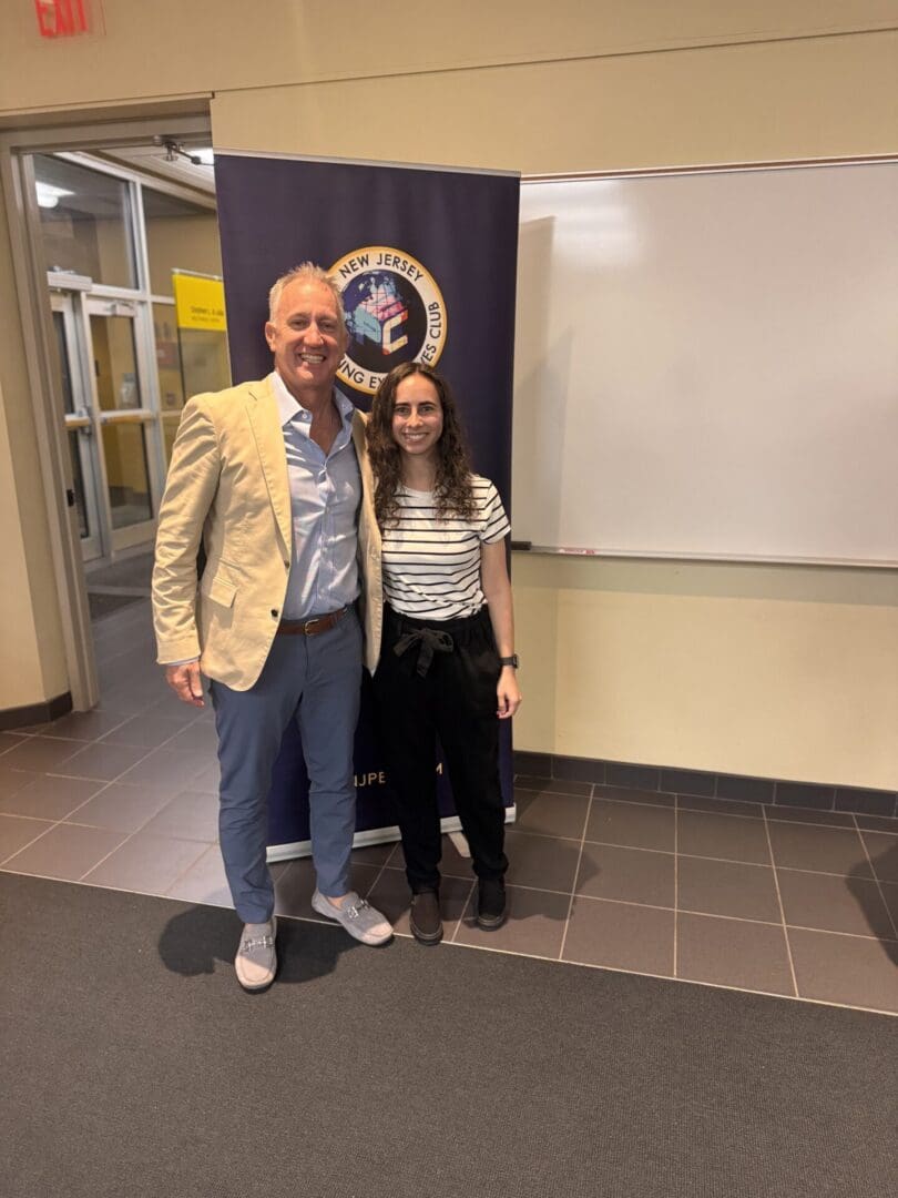 Two people standing in front of banner.